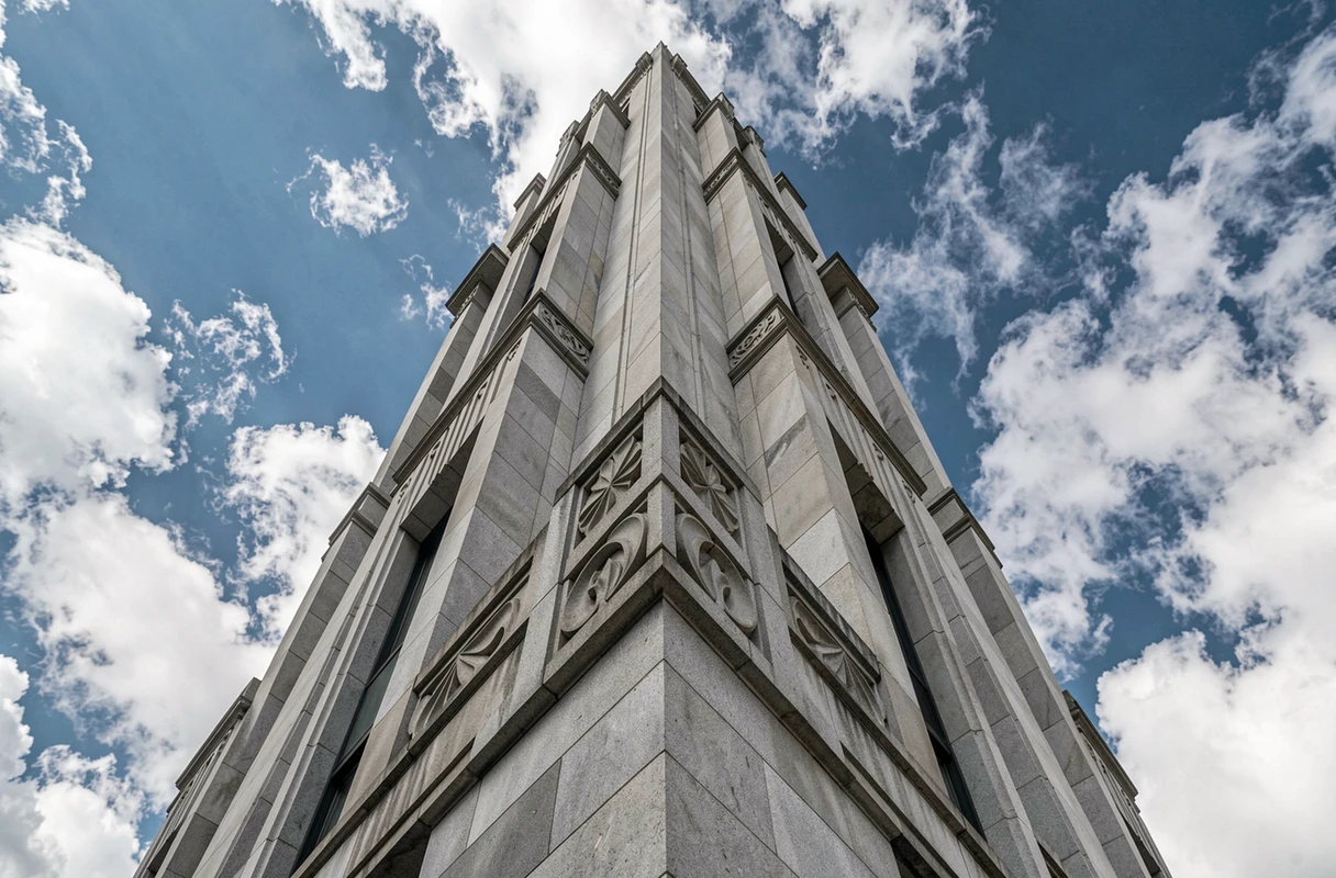 Contre-plongée dramatique sur la façade d'un gratte-ciel Art Déco aux ornements géométriques s'élevant vers le ciel